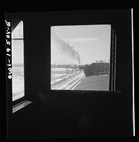 Streator (vicinity), Illinois. Passing an eastbound freight train on the Atchison, Topeka and Santa Fe Railroad between Chicago and Chillicothe, Illinois. Seen through the window of the cupola. Sourced from the Library of Congress.