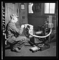 [Untitled photo, possibly related to: Fort Madison, Iowa. In the train control room at the Shopton shops of the Atchison, Topeka and Santa Fe Railroad. Testing the governor of a train control mechanism]. Sourced from the Library of Congress.