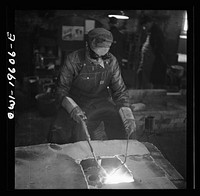 Fort Madison, Iowa. Welding cracks in the cylinder head of a diesel engine at the Shopton locomotive shops of the Atchison, Topeka, and Santa Fe Railroad. Sourced from the Library of Congress.
