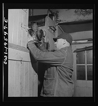 As darkness approaches, brakeman M. H. Burdette lights his markers and gets them ready to hang on the rear end of the caboose on the Atchison, Topeka and Santa Fe Railroad between Chillicothe, Illinois and Fort Madison, Iowa. Sourced from the Library of Congress.