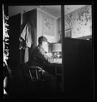 [Untitled photo, possibly related to: A conductor studying a timetable in the caboose on the Atchison, Topeka and Santa Fe Railroad between Chillicothe, Illinois and Fort Madison, Iowa]. Sourced from the Library of Congress.