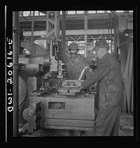 [Untitled photo, possibly related to: Clovis, New Mexico. Private Frank Donath of Sedalia, Missouri, learning to use a shaper under the direction of A.R. Rose, machinist at the Atchison, Topeka and Santa Fe Railroad locomotive shops. Private Donath is a member of the United States Army railroad battaloin stationed at Clovis]. Sourced from the Library of Congress.