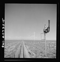 [Untitled photo, possibly related to: Willard, New Mexico. Flagman walks back to flag any oncoming trains his train stops for water between Vaughn and Belen, New Mexico on the Atchison, Topeka and Santa Fe Railroad]. Sourced from the Library of Congress.