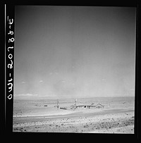 [Untitled photo, possibly related to: Willard, New Mexico. Passing a filling station in the desert country along the Atchison, Topeka and Santa Fe Railroad between Vaughn and Belen, New Mexico]. Sourced from the Library of Congress.