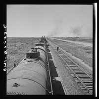 Tolar, New Mexico. Atchison, Topeka, and Santa Fe Railroad train between Clovis and Vaughn, New Mexico stopping for water. A brakeman walking the length of the train for inspection. Sourced from the Library of Congress.