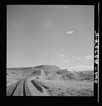 Coming out of the mountains on the Atchison, Topeka and Santa Fe Railroad between Vaughn and Belen, New Mexico into the Rio Grande River Valley. In the distance is a quarry on the mountainside where the railroad gets its rock for ballast. Sourced from the Library of Congress.