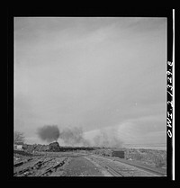 [Untitled photo, possibly related to: Gleed (vicinity), Arizona. A freight train going around a curve on the Atchison, Topeka and Santa Fe Railroad between Winslow and Seligman, Arizona]. Sourced from the Library of Congress.
