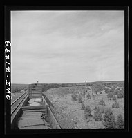 [Untitled photo, possibly related to: A diesel freight train on the Atchison, Topeka and Santa Fe Railroad between Winslow and Seligman, Arizona going down the mountains from Supai to Ash Fork, Arizona, a drop of about 1600 feet. A brakeman is riding on the top of the car. He stays on as far as Ash Fork, to operate the retainers]. Sourced from the Library of Congress.