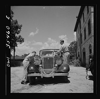 Bowman, South Carolina. Sergeant John Riley of the 25th service group, Air Service Command, on leave at his home. With the help of a friend, he is cleaning his little Ford, preparing to go see his girlfriend in Charleston, South Carolina. Sourced from the Library of Congress.