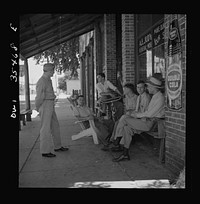 Bowman, South Carolina. Sergeant John Riley of the 25th service group, Air Service Command, talking with friends while on leave at his home. Before enlisting in the Army, Sergeant Riley worked in his father's garage for many years. Sourced from the Library of Congress.