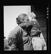 [Untitled photo, possibly related to: Woman packinghouse worker from Tennessee trying to wash  muck, which causes an itchy rash and sores, off her youngest child. She has three others. The water came from a filthy canal nearby. Belle Glade, Florida]. Sourced from the Library of Congress.