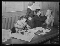 Doctor and nurse (Miss Teal) giving examination and treatment for hookworm to one of children in Goodman School health room. Coffee County, Alabama. Sourced from the Library of Congress.