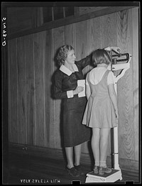 Nurse, Miss Teal, weighing child in health room of Goodman School. Coffee County, Alabama. Sourced from the Library of Congress.