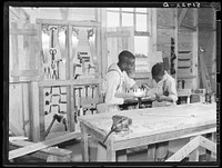 J.W. West and John Young sharpening crosscut saw in school shop class. Flint River Farms, Georgia. Sourced from the Library of Congress.