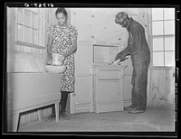 Project family in kitchen of their new home, showing cabinet and flour bin they built. Prairie Farms, Alabama. Sourced from the Library of Congress.