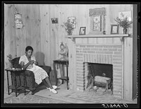 Daughter of Frederick Oliver, tenant purchase client, sewing in living room of new home. Summerton, South Carolina. Sourced from the Library of Congress.