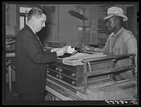 The business manager on Marcella Plantation paying off one of the tenants. Saturday, Mileston, Mississippi Delta, Mississippi. Sourced from the Library of Congress.