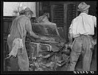 Removing chinese hair mat from cake of cottonseed meal. This meal is fed to cattle. Clarksdale, Mississippi Delta. Sourced from the Library of Congress.
