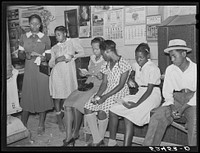es help each other read their mail in plantation store on Saturday morning. Mileston Plantation, Mississippi Delta. Sourced from the Library of Congress.