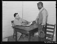 [Untitled photo, possibly related to: Good Hope Plantation manager paying off on Saturday in plantation store. Mileston, Mississippi]. Sourced from the Library of Congress.
