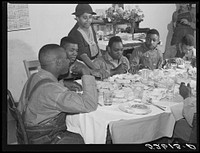 [Untitled photo, possibly related to: The  tenants and neighbors eating dinner after the white men have finished on day of corn-shucking at Mrs. Fred Wilkins' home. Tallyho, Stem, Granville County, North Carolina]. Sourced from the Library of Congress.