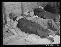 Farmers sleeping in white camp room in warehouse. They often must remain overnight or several days before their tobacco is auctioned. Durham, North Carolina. Sourced from the Library of Congress.