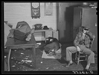 Farmers must often wait overnight before their tobacco is sold at auction. They sleep most anywhere. This is interior of the office in the warehouse about four o'clock in the morning. Durham, North Carolina. Sourced from the Library of Congress.