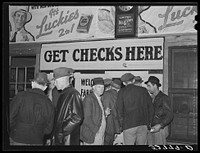 Farmers in warehouse getting their checks after tobacco auction sale. Durham, North Carolina. Sourced from the Library of Congress.