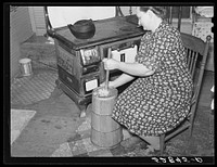 Mrs. Elvin Wilkins (Rosa) churning butter in the kitchen of their home in Tallyho, near Stem, Granville County, North Carolina. See subregional notes (Odum) November 16, 1939. Sourced from the Library of Congress.