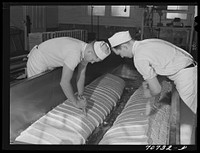 Cutting through the curd which has cheddared, and thus releasing the whey. Tillamook cheese plant, Tillamook, Oregon by Russell Lee