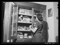 Mrs. Lee Wagoner, wife of Black Canyon Project farmer, sets the table for dinner. Canyon County, Idaho by Russell Lee