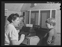[Untitled photo, possibly related to: The FSA (Farm Security Administration) nurse types out dental record of migrant child in the dental trailer while at the FSA camp for farm workers. Caldwell, Idaho] by Russell Lee