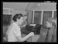 The FSA (Farm Security Administration) nurse types out dental record of migrant child in the dental trailer while at the FSA camp for farm workers. Caldwell, Idaho by Russell Lee