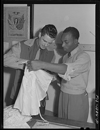 Chief inspector of the Standard Parachute Company and "Skippy" Smith, manager of the Pacific Parachute Company, examining a pilot parachute. San Diego, California by Russell Lee