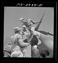 Working on the nose of one engine of an interceptor plane. Lake Muroc, California by Russell Lee