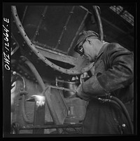 Chicago, Illinois. Cutting a metal part for a locomotive at the Chicago and Northwestern Railroad repair shops. Sourced from the Library of Congress.