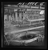 Great Falls, Montana. Anaconda Wire and Cable Company. Billet heating furnace and intermediate rolls where the copper wire bar, which is the blunt white bar in left center, is converted to the rod at its immediate right and further reduced to size of that shown in right foreground by Russell Lee