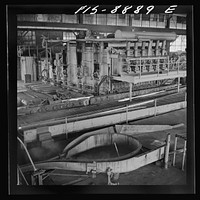 Anaconda smelter, Montana. Anaconda Copper Mining Company. Copper converter in action. Object of converting is to eliminate sulphur and iron; this is accomplished by blowing compressed air through the molten charge. The oxidation products unite with silica which is added to form a slag which floats on the surface and is easily skimmed off by Russell Lee