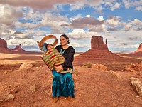 Navajo Eula Matene hold three-month-old Leon Clark on a ridge in the Arizona portion of Monument Valley, a red-sand desert region on the Arizona-Utah border known for the towering sandstone buttes of Monument Valley Navajo Tribal Park. The park, frequently a filming location for Western movies, is accessed by the looping, 17-mile Valley Drive.