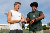 Athlete and coach discussing fitness tracker and performance