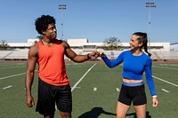 Male and female athletes fist bumping