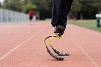 Athlete with prosthetic legs on a running track 