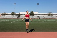 Woman athlete skipping rope in a stadium 