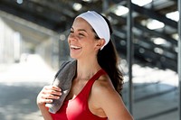 Smiling female athlete with towel and headband 