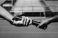 Team mates passing a relay baton 