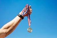 Man holding a gold medal after winning a race 