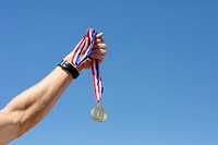 Man holding a gold medal after winning a race 