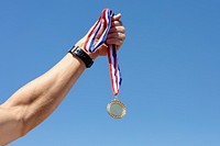 Man holding a gold medal after winning a race psd