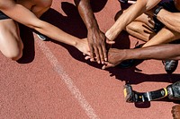 Team of diverse athletes stacking hand before the race