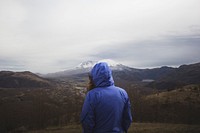 Free blue jacket person looking at mountain in image, public domain human CC0 photo.